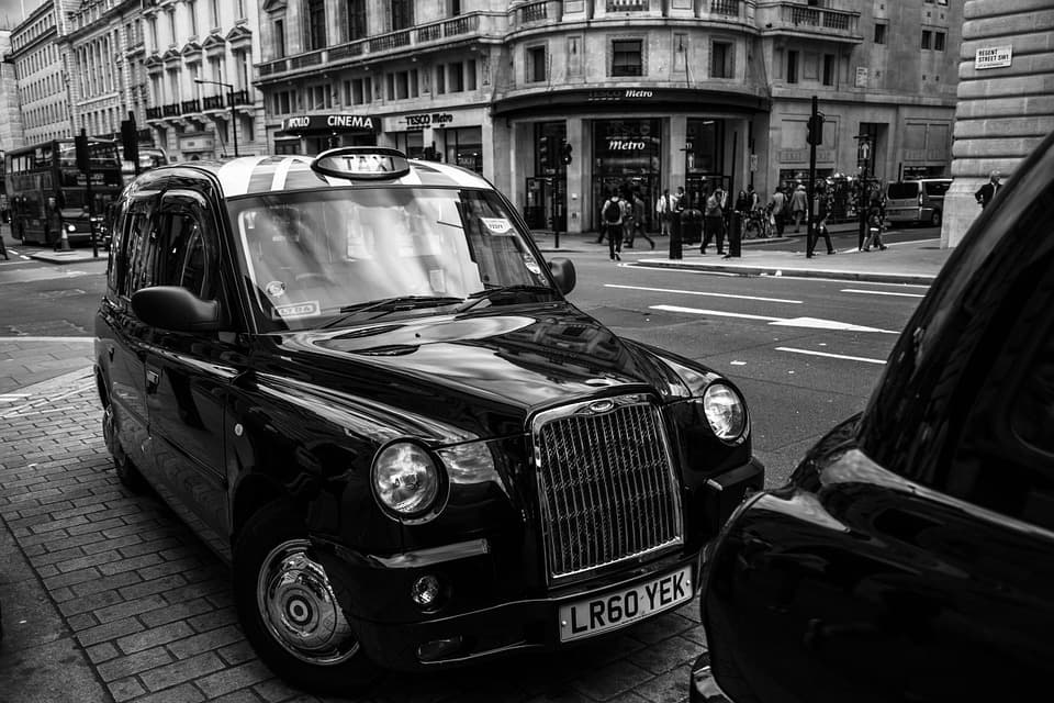 Professional driver helping a passenger into a luxury vehicle