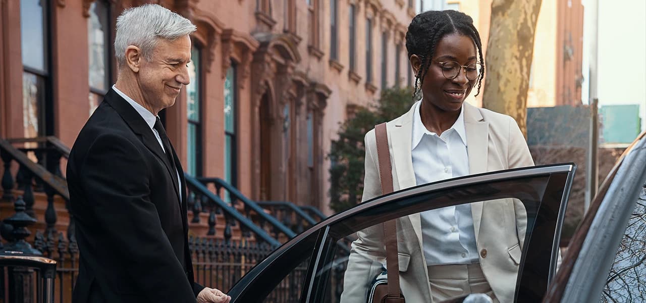 Chauffeur opening car door for client