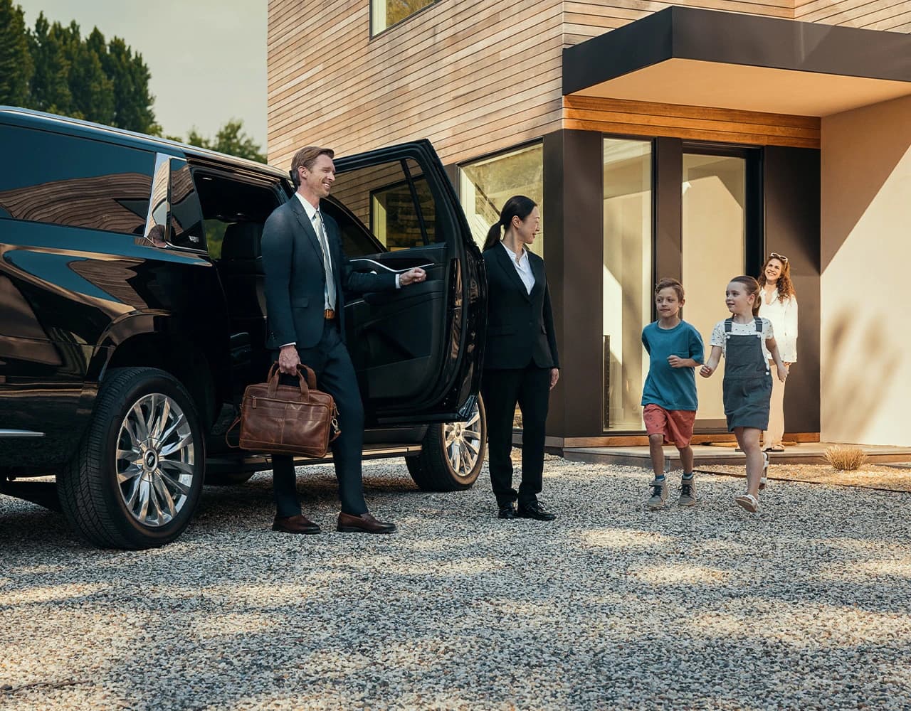 Family with chauffeur and luxury SUV